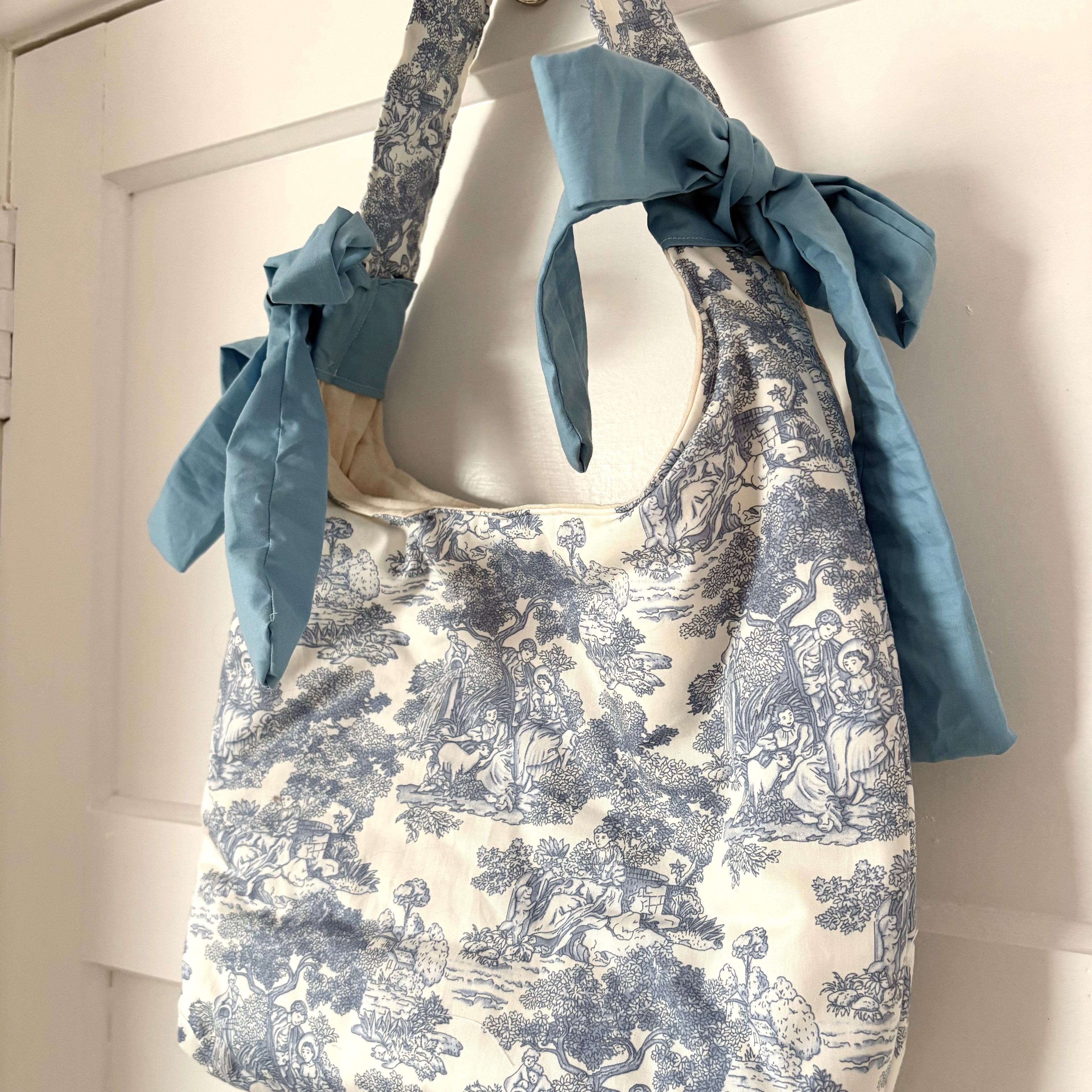 Handmade white and blue porcelain coquette farm print padded tote bag with blue bows