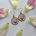 Pink circle with flowers and butterfly dangle gold earrings
