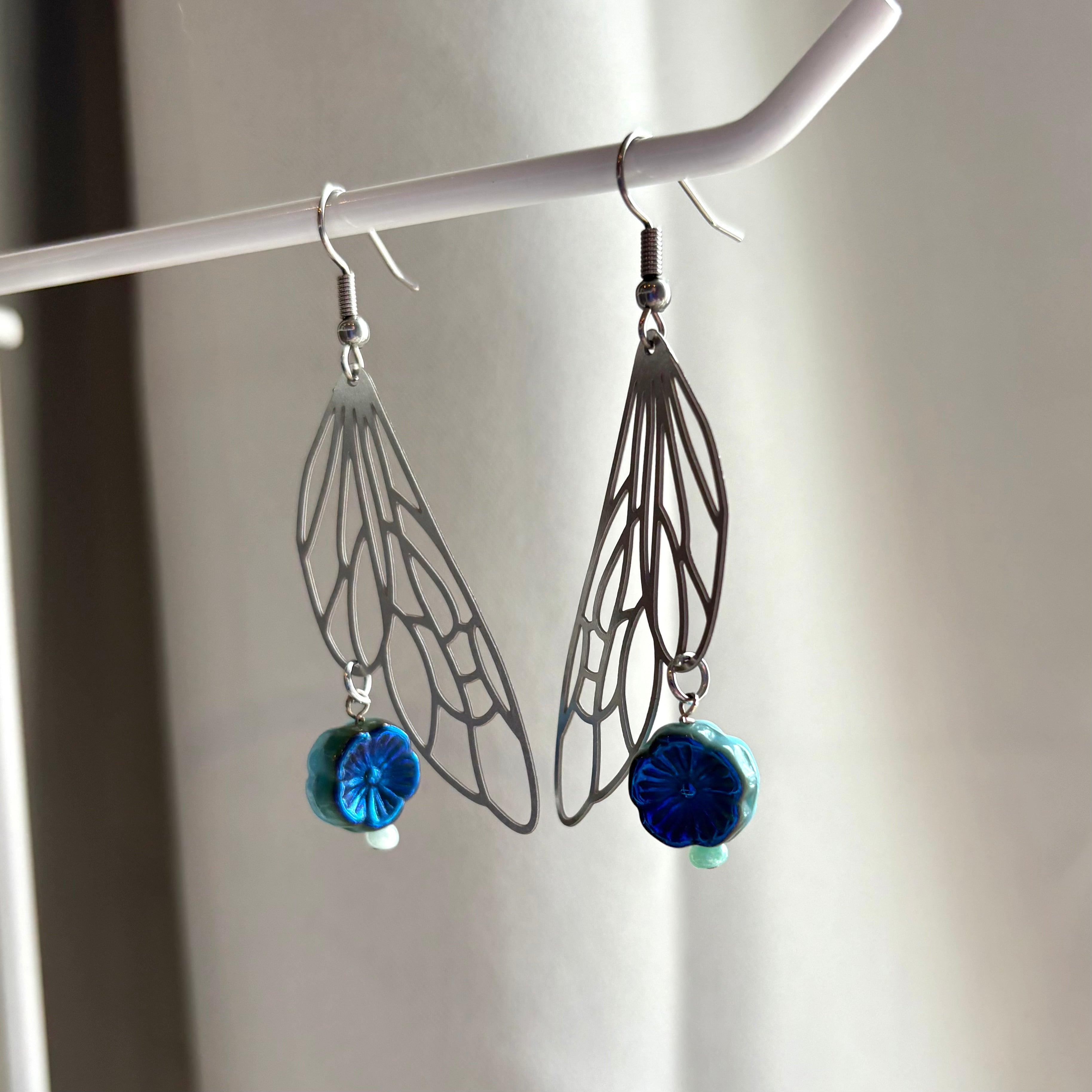 Stainless steel silver fairy wing dangle earrings with blue reversible blue flowers