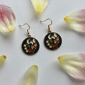 Navy blue circle with flowers and butterfly gold earrings